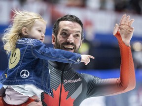 Charles Hamelin of Canada waves to the crowd with his daughter Violette following the 5000-metre relay final at the ISU World Short Track Speed Skating Championships in Montreal, Sunday, April 10, 2022.