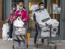 People wear masks as they leave a shopping mall in downtown Montreal on Wednesday, May 4, 2022. Public health officials announced the end of mask mandates in most situations starting May 14.