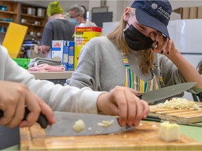 John Rennie High School students, including 12-year-old Yosdi Pivotal out of frame and 13-year-old Anne-Marie Rene are taught after-school cooking skills in Pointe-Claire on Friday April 29.
