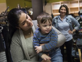Yulia El Hilali holds son Anwar at the Ukrainian Newcomers Centre, as volunteer Tatiana Romano looks on. "Every time I come here, the doors are open," El Hilali says.