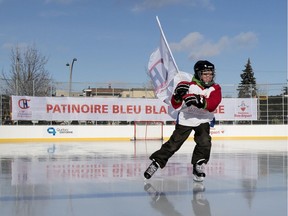 Renault, a young boy from Ecole Leon Guilbault, carries the Montreal Canadiens Foundation flag as he is the first skater to open the new Montreal Canadiens Foundation Blue Blanc Rouge rink in Parc Émile in Laval on Jan. 11, 2016.