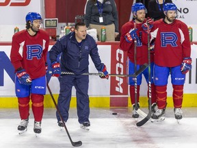 Laval Rocket head coach Jean-François Houle yells instructions while standing between Tory Dello, left, Brandon Gignac and Cédric Paquette, right, during practice at the Place Bell Sports Complex in Laval on May 11, 2022.