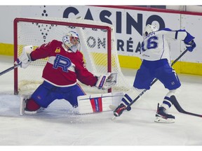 Laval Rocket goalie Cayden Primeau stretches across his crease to make a save on Syracuse Crunch's Otto Somppi during  first period of Game 4 at the Place Bell Sports Complex in Laval on May 14, 2022.