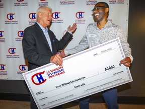 Réjean Houle, left, president of the Montreal Canadiens Alumni Association, with Trevor Williams, holding a cheque from the Montreal Canadiens Children's Foundation at the Bell Centre in Montreal on Tuesday, May 17, 2022.  Houle is a member of the Foundation's board of directors, while Williams runs the Trevor Williams Kids Foundation.