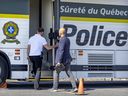 Sûreté du Québec investigators enter the command post set up on Curé-Labelle Blvd. in Laval on Wednesday.