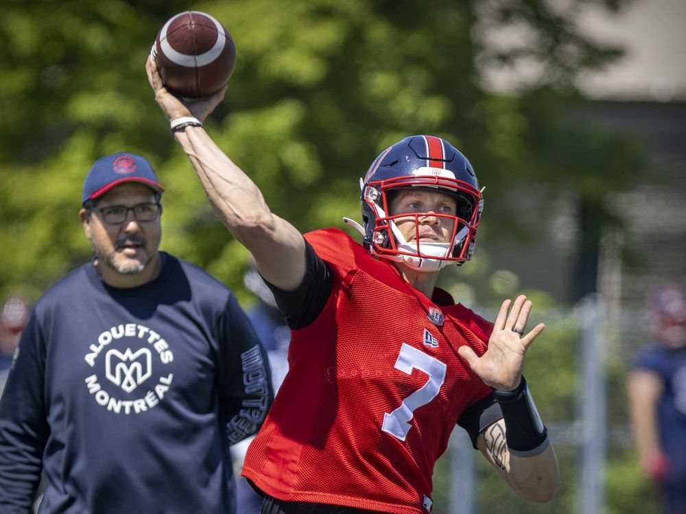 Montreal Alouettes pivot Trevor Harris throws a pass in front of quarterbacks coach Anthony Calvillo during training camp practice in Trois-Rivières on May 25, 2022.