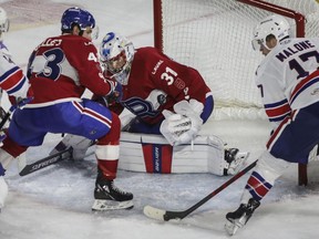 Rocket's Cayden Primeau stymies Rochester's Sean Malone while Xavier Ouellet looks on during the third period of Game 2 of the AHL North Division final at Place Bell on Monday.