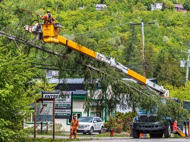 Hydro workers were tending to tree branches on power lines in the Morin-Heights area on Tuesday May 24, 2022.