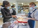 Kaitlyn Marshall, right, makes cookies with visitor Sara Amina during an open house last week at L’Équipe Entreprise, which helps individuals living with mental health problems improve their work skills. Cooking instructor Sharmila Boodhun (rear left) supervises.
