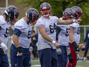 Centre Sean Jamieson, 64, points out defensive assignments to fellow offensive linemen during Alouettes training camp in Trois-Rivieères on Thursday.