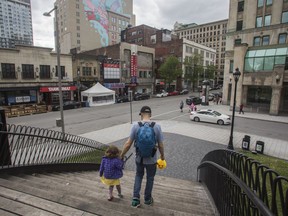 Riley Drever and daughter Esmée in Dorchester Square in the downtown area of Montreal Saturday, May 28, 2022. Two of the biggest challenges Montreal is facing are how to revive downtown, which was hollowed out by the pandemic, and how to ease a growing housing crisis, where affordability and availability are squeezing renters and buyers alike.