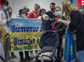 Eine ukrainische Frau mit einem Baby wird am Sonntag, den 29. Mai 2022, am Flughafen Trudeau in Montreal von einer Frau begrüßt. Sie gehörte zu 305 Ukrainern, die mit einem Flug aus Warschau ankamen.