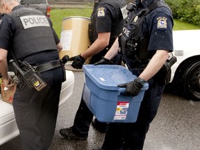 Laval police leave a residence in 2013 with items seized in a drug raid. One way that the war on drugs causes harm is that police seizures of clean drugs leave users to rely on impure supplies, a factor that contributes to drug overdoses, Ted Rutland says.