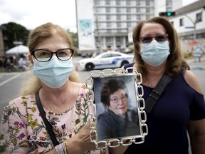 Sisters Sabina Lanzolla, left, and Nancy Lanzolla hold a picture of their mother, Giacomina Scattaglia-Lanzolla at a vigil for those that passed away from Covid-19 at Résidence Angelica in Montreal on July 23, 2020.