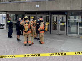 STM employees and firefighters stand outside the Lionel-Groulx métro station on Tuesday, May 3, 2022, after métro service was disrupted by an apparent electrical fire.