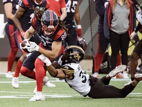 Montreal Alouettes receiver Krishawn Hogan is brought down by Hamilton Tiger-Cats linebacker Patrick Nelson during pre-season game on May 28, 2022, in Hamilton.