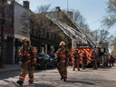 Firefighters walk away from the scene of a fire just north of the intersection of St-Laurent Blvd. and Prince Arthur St. that went from a one-alarm fire to a four-alarm fire very quickly on Saturday, May 7, 2022, in Montreal. No injuries were reported. 