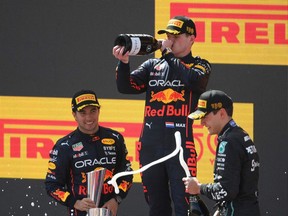 Red Bull's Dutch driver Max Verstappen (C), Red Bull's Mexican driver Sergio Perez (L) and Mercedes' British driver George Russell celebrate on the podium after the Spanish Formula One Grand Prix at the Circuit de Catalunya on May 21, 2022