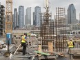 Construction workers in Griffintown, with the city skyline on Monday, May 16, 2022.
