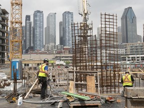 Construction workers in Griffintown, with the city skyline in May 2022.