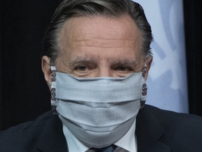 Le premier ministre François Legault arrive en conférence de presse sur la pandémie de COVID-19 portant un masque, le mardi 12 mai 2020 à l'Assemblée législative de Québec.