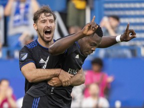 CF Montréal's Sunusi Ibrahim, right, celebrates his first of three goals Wednesday night with teammate Matko Miljevic in game against Hamilton's Forge FC during Canadian Championship quarter-final action at Stade Saputo.