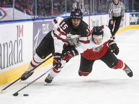 Canada's Shane Wright (15) battles Austria's Tobias Sablattnig during a World Junior Hockey Championship game in December.