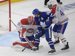 Montreal Canadiens goalkeeper Carrie Price tackles defender Joel Edmondson and covers Toronto Maple Leafs forward Mitch Marner in Game Seven of the first round of the 2021 Stanley Cup playoffs. Marner has been goalless for the duration of the series.