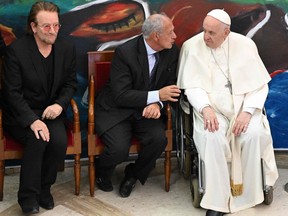 Pope Francis, right, Jose Maria del Corral, centre, founder of Scholas Occurrentes and frontman of Irish rock band U2, Bono, attend on May 19, 2022 at the Pontifical Urbaniana University in Rome, the launch of the Scholas Occurrentes International Movement.