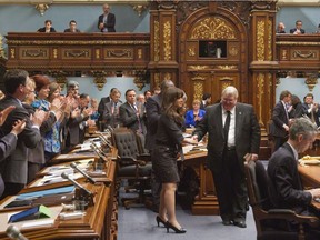 Members of the Quebec legislature applaud Véronique Hivon, left and former Quebec Health minister Gaétan Barrette on Thursday, May 22, 2014 in Quebec City. Both MNAs have decided not to seek re-election in the fall.