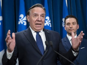Quebec Premier François Legault responds to reporters questions after Bill 96, a legislation modifying Quebec's language law, was voted, Tuesday, May 24, 2022 at the legislature in Quebec City. Simon Jolin-Barrette, Minister Responsible for the French Language, right, looks on.