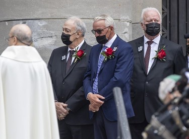 Former Montreal Canadiens Guy Lapointe, left, Mario Tremblay and Yvon Lambert, right, gather outside Mary Queen of the World Cathedral following Guy Lafleur's funeral in Montreal Tuesday May 3, 2022.