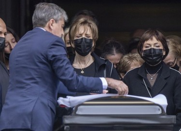 Guy Lafleur's widow Lise, left, watches as the Montreal Canadiens flag that had been draped his coffin is folded outside Mary Queen of the World Cathedral in Montreal following his funeral Tuesday, May 3, 2022.