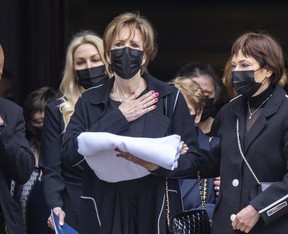 Guy Lafleur's widow Lise touches her heart to acknowledge the crowd outside Mary Queen of the World Cathedral in Montreal following his funeral Tuesday, May 3, 2022.