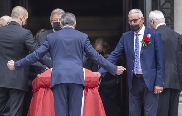 Former Montreal Canadien Mario Tremblay reaches to touch Guy Lafleur's coffin as he exits Mary Queen of the World Cathedral in Montreal following Lafleur's funeral Tuesday, May 3, 2022.