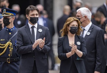 Prime Minister Justin Trudeau and wife Sophie Grégoire clap as the hearse carrying Guy Lafleur's coffin passes Mary Queen of the World Cathedral after his funeral in Montreal Tuesday, May 3, 2022.