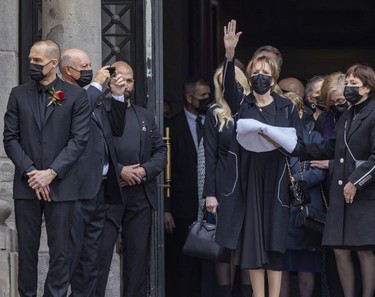 Steve Shutt (second  from left), former Montreal Canadiens linemate of Guy Lafleur, shoots video of Lafleur's widow Lise as she wave to the crowd outside Mary Queen of the World Cathedral in Montreal following Lafleur's funeral Tuesday, May 3, 2022.