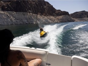 A jet skier plays in the wake of a boat.