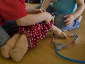 Toddlers playing doctor appear to check a doll's ears at their Montreal-area home in 2008.