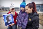 Lynne Baudouy and Guy Gaudet with daughter Angele outside St. Thomas High School in Pointe-Claire, in April. Their son Lucas died after being stabbed during an altercation near the school in February.