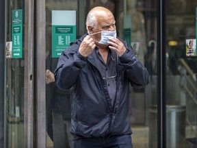 A man removes his mask after exiting a downtown department store in Montreal.