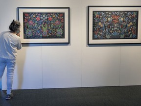 A woman looks at artwork by Christi Belcourt at the Land Back contemporary native art exhibit at Stewart Hall in Pointe-Claire.