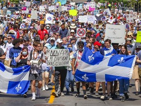 Demonstrators walk down Atwater Ave. during a rally to oppose Bill 96 in Montreal Saturday May 14, 2022.