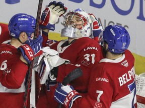 Goalie Cayden Primeau is congratulated by Laval Rocket teammates Corey Schueneman (left) and Louie Belpedio after the team's victory over the Rochester Americans in Game 2 between Laval Rocket and Rochester Americans AHL North Division final playoff series at Place Bell in Laval on May 23, 2022.