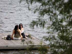 Lisa Charron, left, and Marianna Vidrak enjoy a moment in the breeze by the water on a wharf in the Verdun May 30, 2022. Charron recently moved nearby after walking her dog along the St. Lawrence River and falling in love with the area.