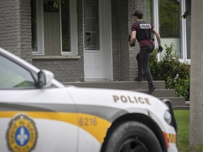 SQ officers arrive at the Delson home of Jérémie Lamontagne, one of four people arrested Wednesday, June 1, 2022 as part of an investigation into gun trafficking.