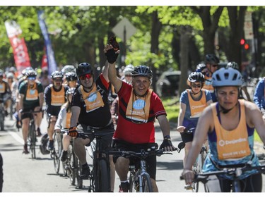 Men gesture as they and others leave the Lafontaine Park area for the Tour de l'Île in Montreal on Sunday, June 5, 2022.