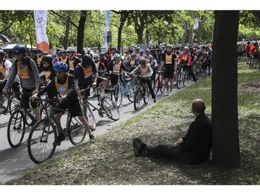 A man watches as people to leave the Lafontaine Park area for the Tour de l'Île in Montreal on Sunday, June 5, 2022.