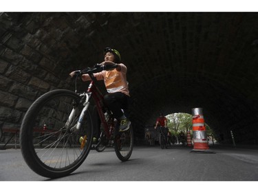 People ride under the railroad viaduct on Glen Road in Westmount as they took part in the Tour de l'Île in Montreal on Sunday, June 5, 2022.
