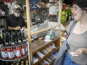 Bakery owner Joseph Cohen, left, talks to client Vanessa Laberge at the Cantor bakery on Tuesday.